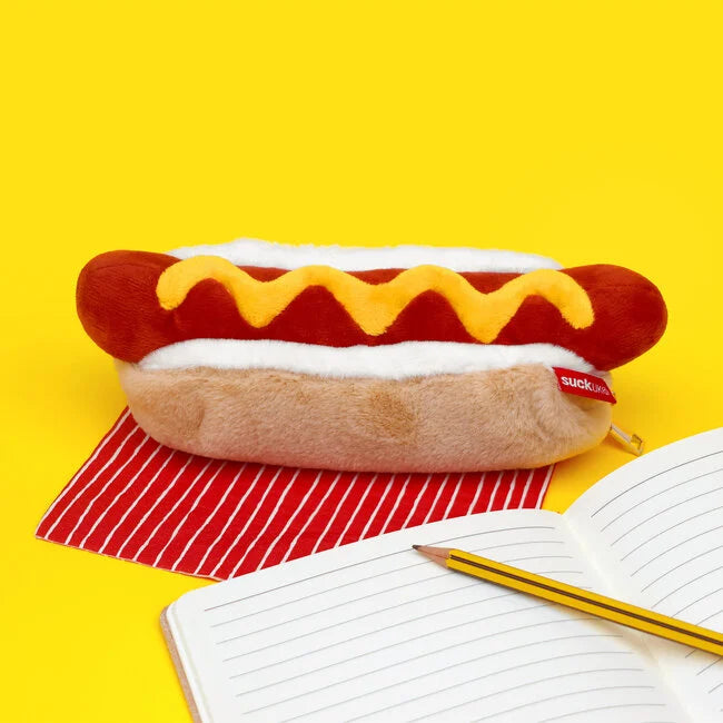Trousse en peluche en forme de hot-dog avec fermeture éclair dorée, ouverte avec des crayons à l’intérieur.